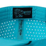 Bright turquoise baseball cap with a black label showing the ’Wiggy Cotton’ brand.