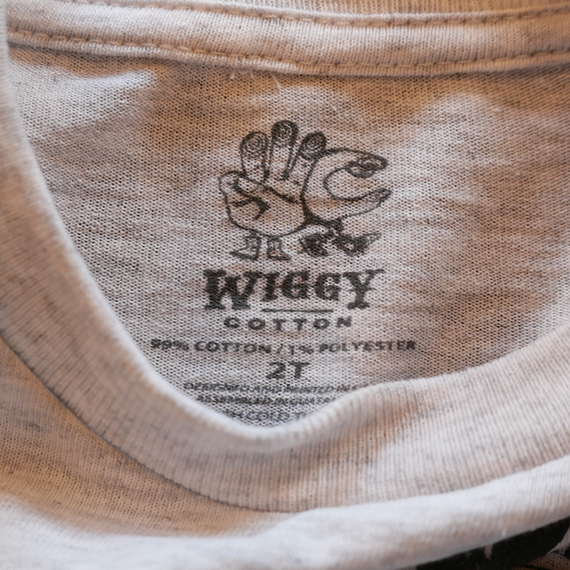 Clothing tag with a hand-shaped turkey logo for the brand ’Widgy Cotton’.