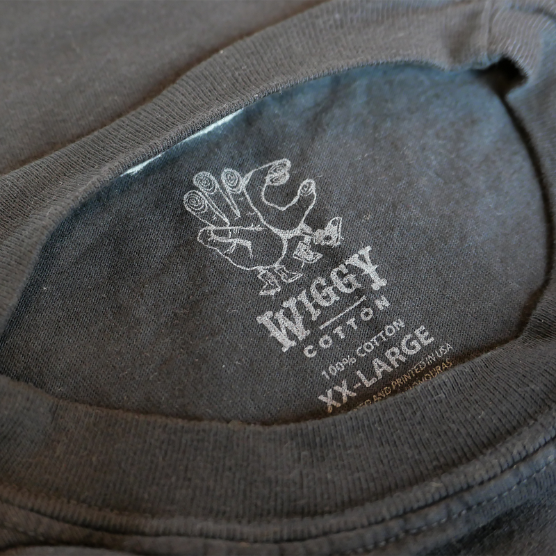 Gray cotton t-shirt collar with a ’Wiggy’ brand logo.